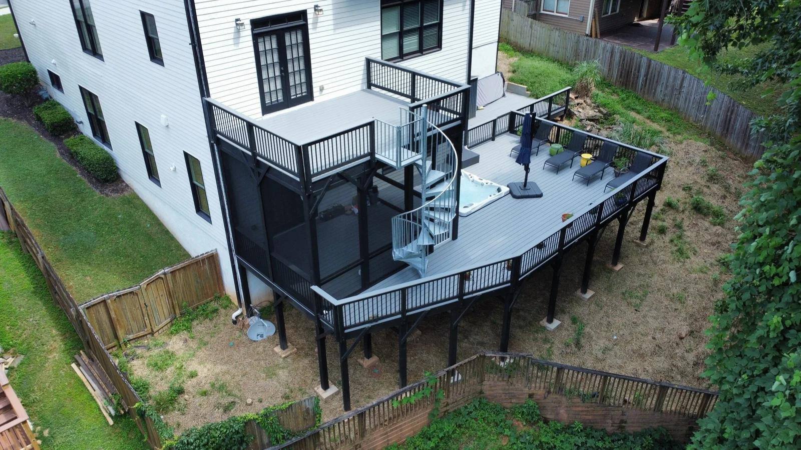 Aerial view of a two-level composite deck with black aluminum railing on a white house