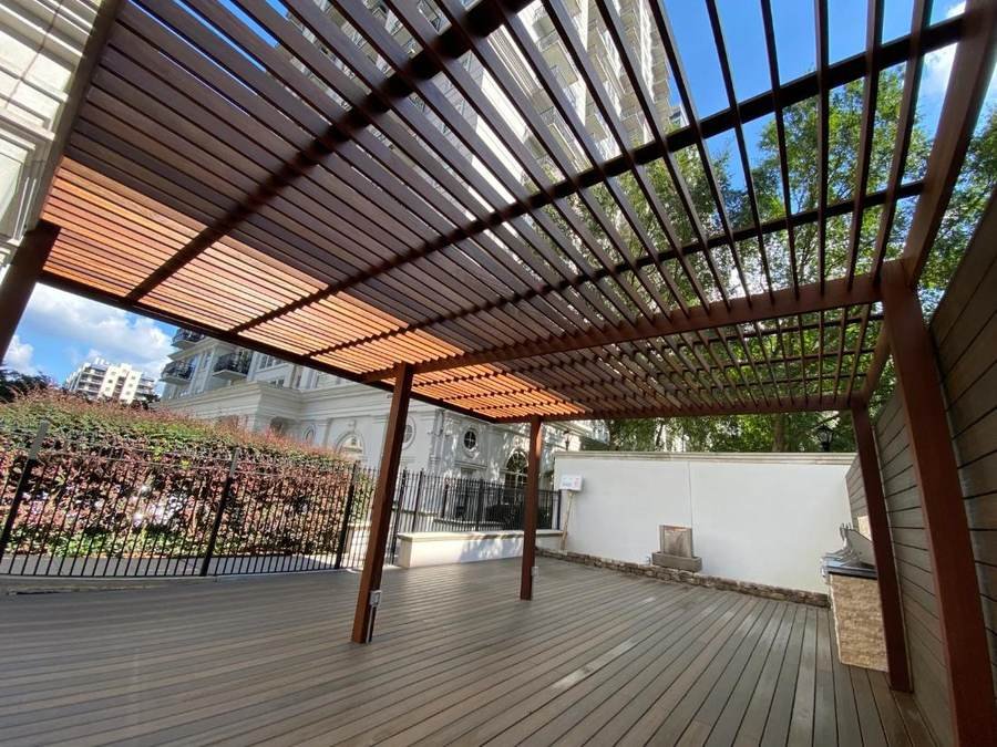 Modern cedar pergola with slatted roof over a composite deck