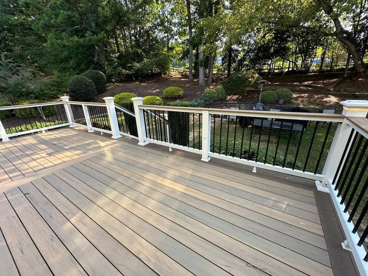 Composite deck with white posts and black balusters overlooking a garden